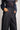 Person wearing a navy lace top and black wide-leg pants on a plain background