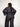 Person wearing a navy lace top and dark gray pants on a white background