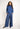 Woman wearing a blue turtleneck and striped pants on a white background