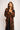 Woman wearing a long, patterned coat against a white background
