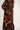 Black and orange patterned cardigan worn by a person on a white background