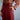 Person wearing a brown blouse and maroon skirt with a blurred background